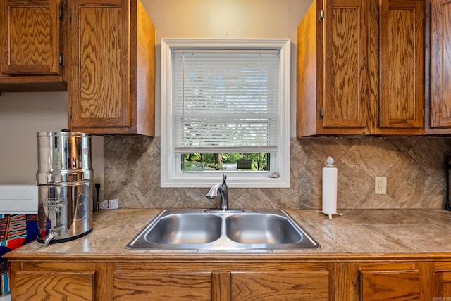 2515 N Dr, North Little Rock, AR 72118 - kitchen with brown cabinetry, backsplash, and light countertops