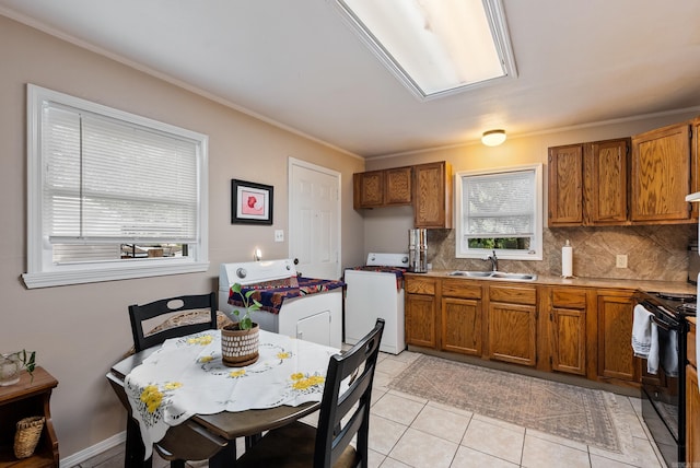 2515 N Dr, North Little Rock, AR 72118 - kitchen with washer / dryer, black range with electric stovetop, brown cabinets, decorative backsplash, and range