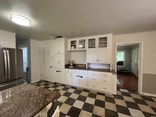 114 Mark Cir, Monticello, AR 71655 - kitchen featuring freestanding refrigerator, dark floors, white cabinets, glass insert cabinets, and dark countertops