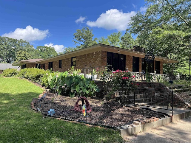114 Mark Cir, Monticello, AR 71655 - view of front of home featuring brick siding, a front yard, and a chimney