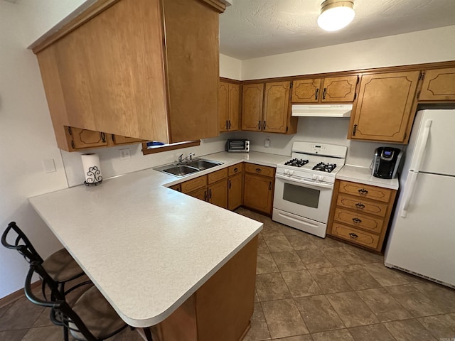 504 Case St, Heber Springs, AR 72543 - kitchen with white appliances, under cabinet range hood, brown cabinets, a peninsula, and light countertops