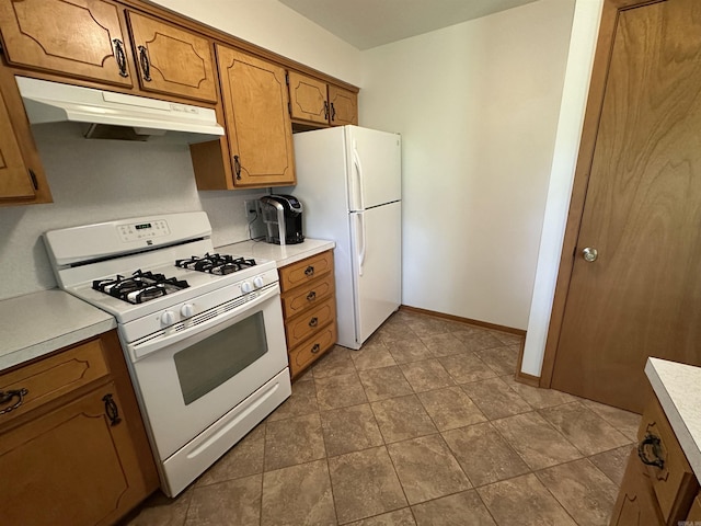 504 Case St, Heber Springs, AR 72543 - kitchen with white appliances, under cabinet range hood, brown cabinetry, and light countertops