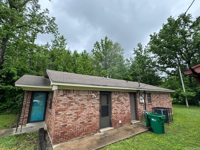4114 W 10th Ave, Pine Bluff, AR 71603 - rear view of property featuring brick siding, a lawn, and a shingled roof