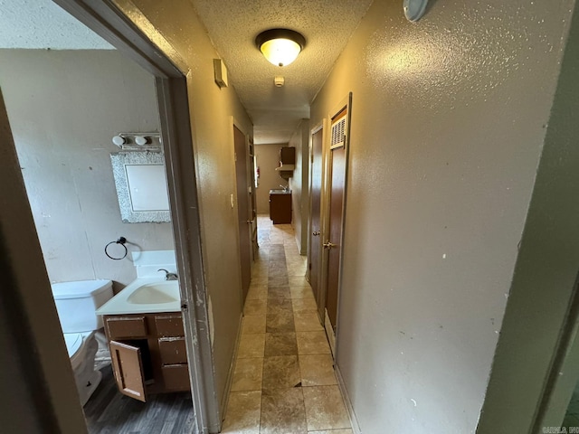 4114 W 10th Ave, Pine Bluff, AR 71603 - corridor featuring a textured ceiling and a sink