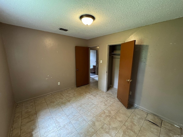 4114 W 10th Ave, Pine Bluff, AR 71603 - unfurnished bedroom with a textured ceiling, a closet, and light tile patterned floors