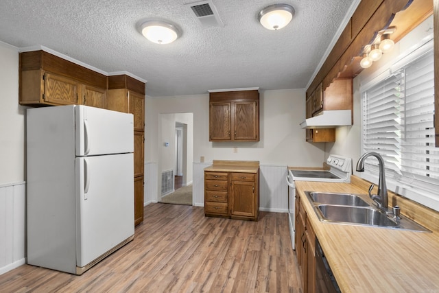 503 N Walnut St, Searcy, AR 72143 - kitchen featuring white appliances, light wood-style floors, a textured ceiling, under cabinet range hood, and light countertops