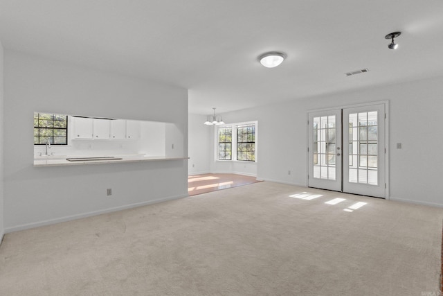 12611 Timber Bend Dr, Little Rock, AR 72211 - unfurnished living room with a chandelier, light colored carpet, and french doors