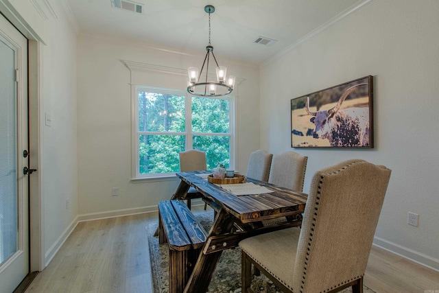 18508 Parkway Pines Dr, Bauxite, AR 72011 - dining area featuring a chandelier, light wood-style floors, and crown molding