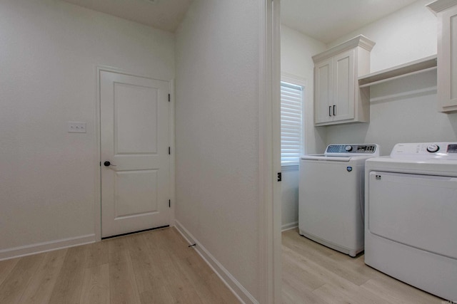 18508 Parkway Pines Dr, Bauxite, AR 72011 - laundry area with light wood-style flooring, cabinet space, and washing machine and clothes dryer
