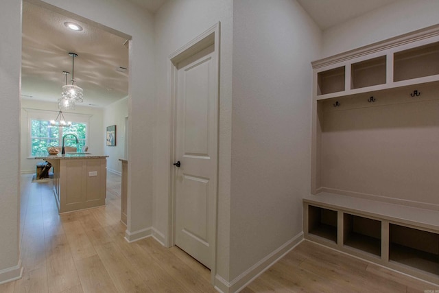 18508 Parkway Pines Dr, Bauxite, AR 72011 - mudroom featuring light wood-type flooring and a chandelier