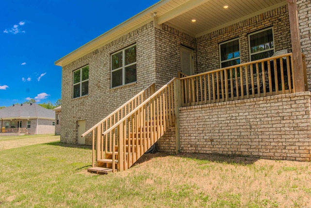 18508 Parkway Pines Dr, Bauxite, AR 72011 - view of exterior entry with brick siding and a lawn