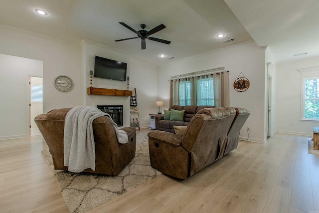 18508 Parkway Pines Dr, Bauxite, AR 72011 - living area with a glass covered fireplace, a ceiling fan, light wood-style floors, crown molding, and recessed lighting