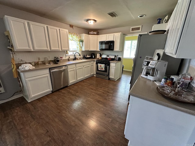 207 Byron St, Beebe, AR 72012 - kitchen with stainless steel appliances, white cabinetry, and dark wood-type flooring