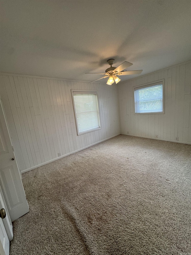 2025 Fairway St, Stuttgart, AR 72160 - carpeted empty room featuring a ceiling fan, wooden walls, and a textured ceiling