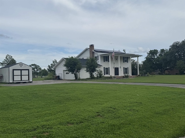 2025 Fairway St, Stuttgart, AR 72160 - view of front facade featuring a shed, a front yard, a chimney, and a garage