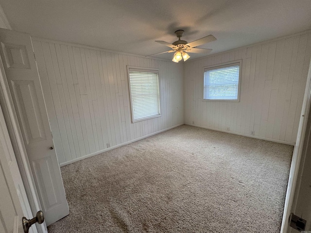 2025 Fairway St, Stuttgart, AR 72160 - carpeted empty room with a ceiling fan and wood walls