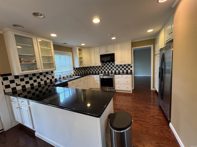 2025 Fairway St, Stuttgart, AR 72160 - kitchen featuring stainless steel appliances, a peninsula, dark countertops, tasteful backsplash, and ornamental molding