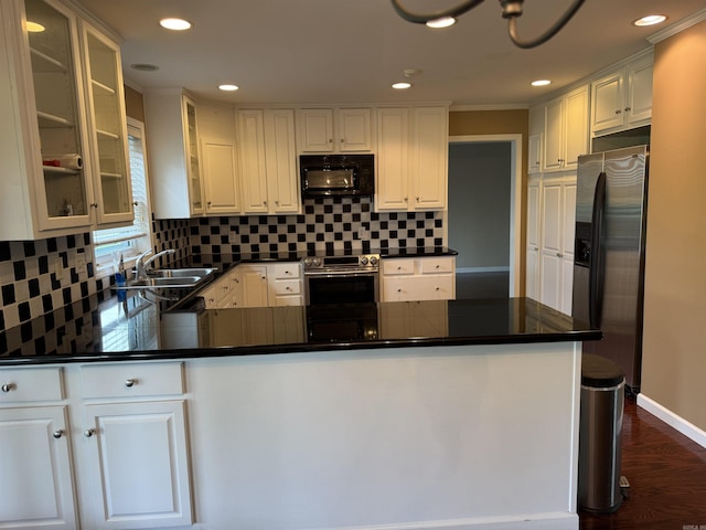 2025 Fairway St, Stuttgart, AR 72160 - kitchen with appliances with stainless steel finishes, dark countertops, a peninsula, decorative backsplash, and recessed lighting