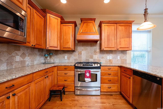 100 Vallon Ln, Little Rock, AR 72223 - kitchen with appliances with stainless steel finishes, custom exhaust hood, ornamental molding, brown cabinetry, and light stone countertops
