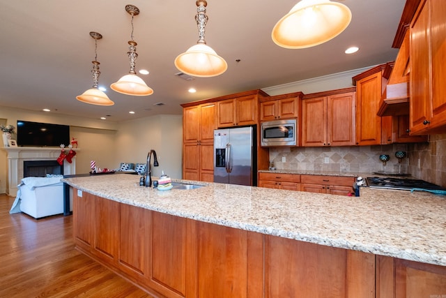 100 Vallon Ln, Little Rock, AR 72223 - kitchen with stainless steel appliances, brown cabinets, light stone countertops, light wood-style floors, and tasteful backsplash