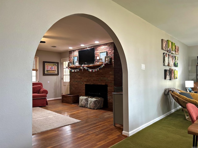 102 Mockingbird Ln, Arkadelphia, AR 71923 - living room featuring a fireplace, wood finished floors, arched walkways, and recessed lighting