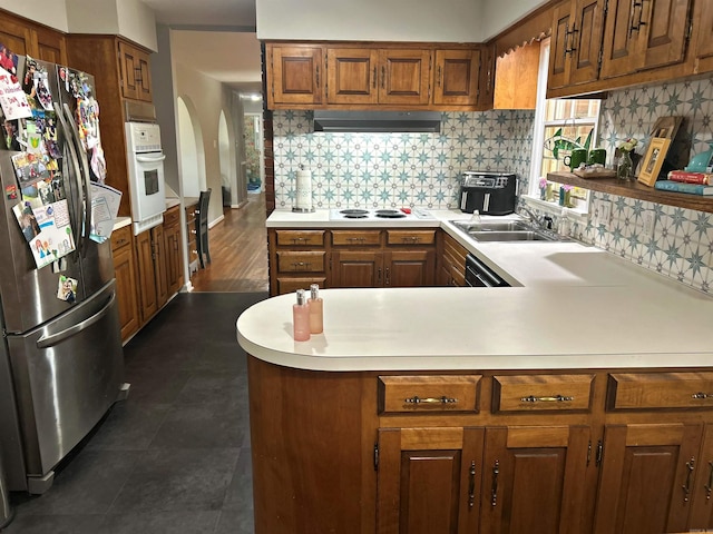 102 Mockingbird Ln, Arkadelphia, AR 71923 - kitchen with white appliances, light countertops, under cabinet range hood, a peninsula, and brown cabinets