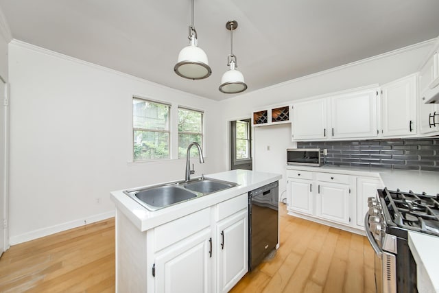 4106 C St, Little Rock, AR 72205 - kitchen featuring appliances with stainless steel finishes, light wood-style flooring, decorative backsplash, white cabinetry, and a kitchen island with sink
