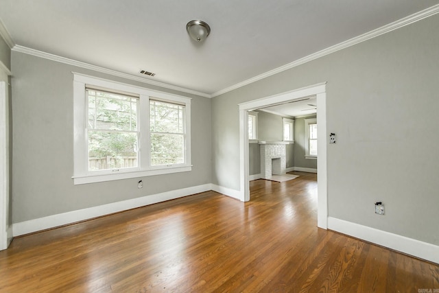 4106 C St, Little Rock, AR 72205 - unfurnished room with ornamental molding, wood finished floors, and a brick fireplace