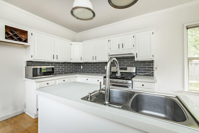 4106 C St, Little Rock, AR 72205 - kitchen with appliances with stainless steel finishes, under cabinet range hood, tasteful backsplash, white cabinets, and crown molding