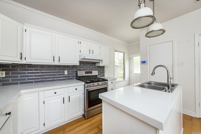 4106 C St, Little Rock, AR 72205 - kitchen with stainless steel range with gas cooktop, under cabinet range hood, white cabinets, decorative backsplash, and ornamental molding