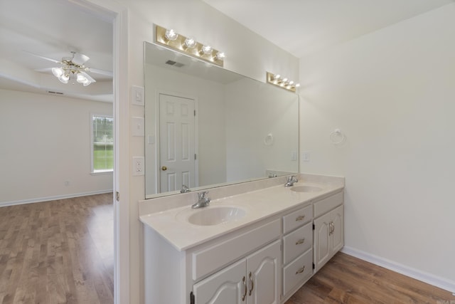 full bath featuring wood finished floors, double vanity, and ceiling fan