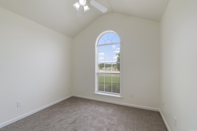 carpeted empty room featuring vaulted ceiling and a ceiling fan