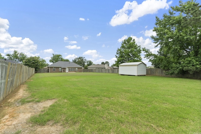fenced backyard featuring a storage unit