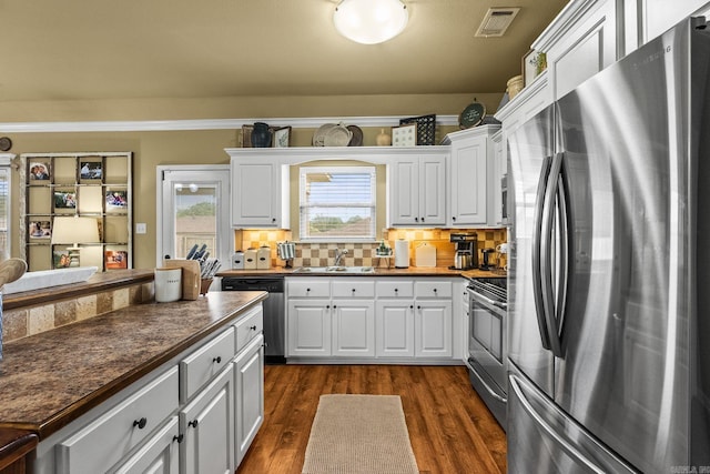 27 Magnolia Ln, Ward, AR 72176 - kitchen featuring appliances with stainless steel finishes, dark countertops, white cabinetry, backsplash, and dark wood-style flooring