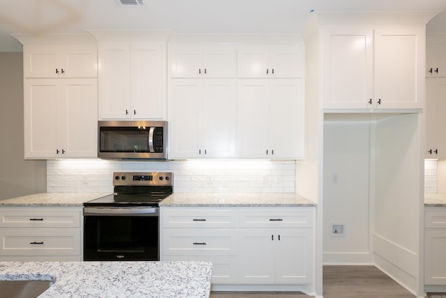 kitchen featuring appliances with stainless steel finishes, backsplash, and white cabinetry