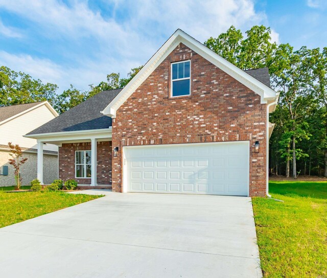traditional-style house with brick siding, concrete driveway, a front lawn, and a shingled roof