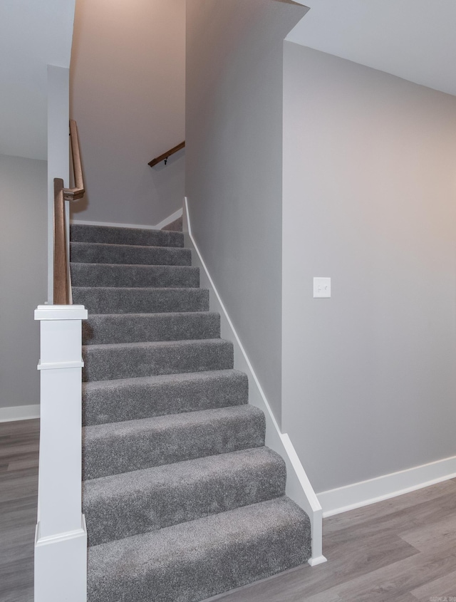 stairway featuring wood finished floors and baseboards