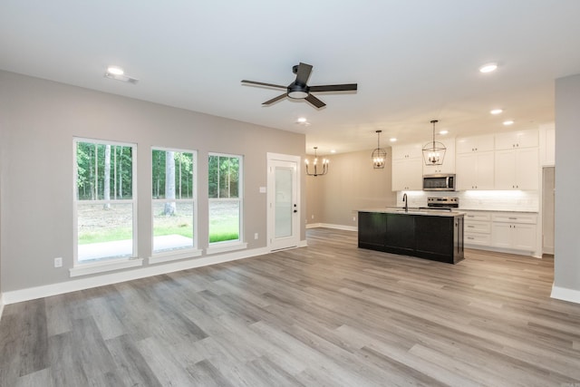 kitchen with stainless steel appliances, a chandelier, recessed lighting, light countertops, and white cabinetry