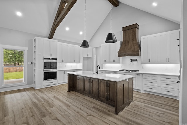 1500 Haley Ln, Conway, AR 72034 - kitchen featuring stainless steel double oven, high vaulted ceiling, custom exhaust hood, gas stovetop, and beam ceiling