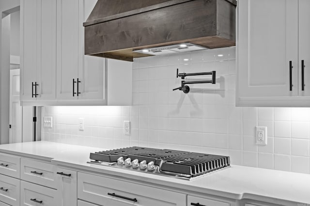 1500 Haley Ln, Conway, AR 72034 - kitchen featuring custom range hood, decorative backsplash, white cabinetry, and stainless steel gas cooktop