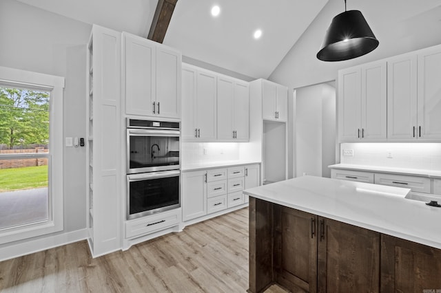 1500 Haley Ln, Conway, AR 72034 - kitchen with double oven, light wood-type flooring, white cabinets, light countertops, and tasteful backsplash