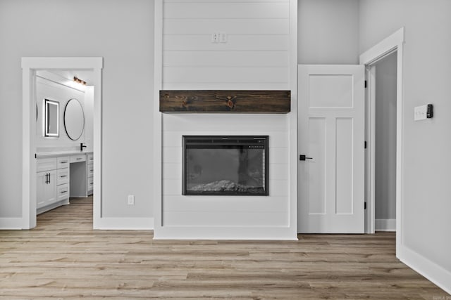 1500 Haley Ln, Conway, AR 72034 - unfurnished living room with light wood finished floors and a glass covered fireplace