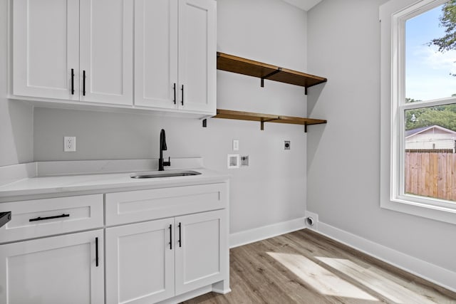 1500 Haley Ln, Conway, AR 72034 - laundry area featuring electric dryer hookup, cabinet space, hookup for a washing machine, and light wood-style floors