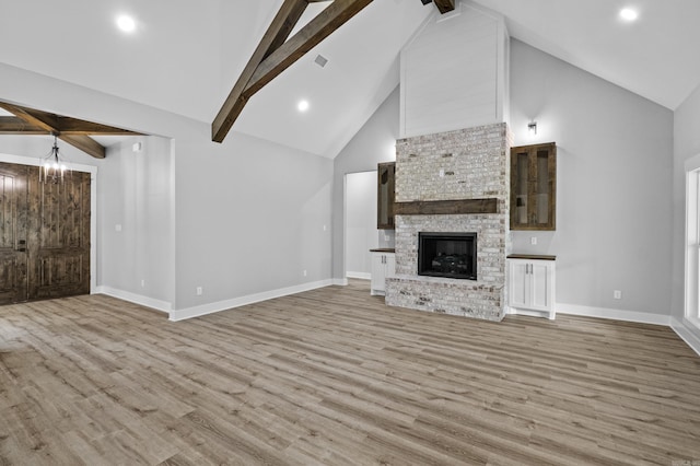 1500 Haley Ln, Conway, AR 72034 - unfurnished living room with high vaulted ceiling, light wood-style floors, beamed ceiling, a fireplace, and recessed lighting
