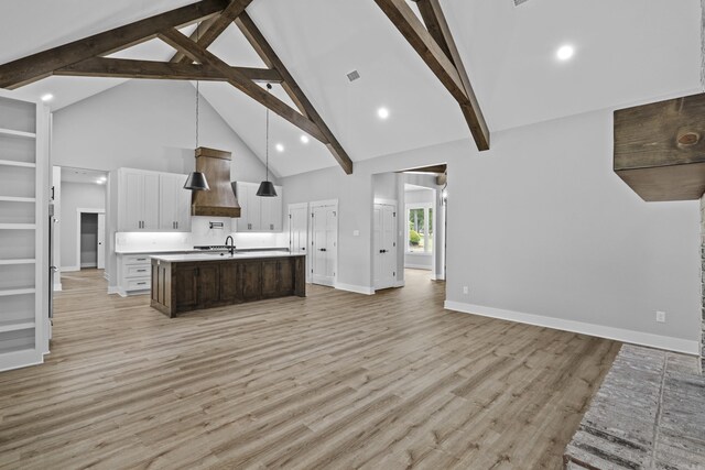 1500 Haley Ln, Conway, AR 72034 - kitchen with custom range hood, open floor plan, high vaulted ceiling, a kitchen island with sink, and light countertops