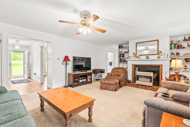 114 Woodiel Cir, Cabot, AR 72023 - carpeted living room with a fireplace, a ceiling fan, and a textured ceiling