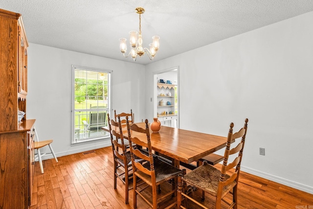 114 Woodiel Cir, Cabot, AR 72023 - dining space featuring light wood-style floors, a chandelier, and a textured ceiling