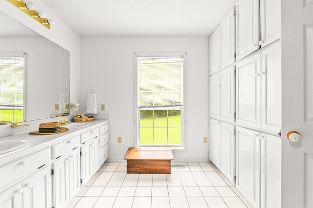 114 Woodiel Cir, Cabot, AR 72023 - bathroom featuring double vanity, healthy amount of natural light, tile patterned flooring, and a textured ceiling