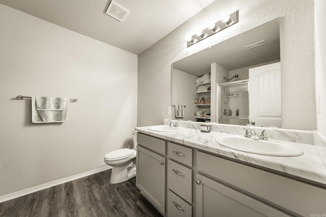 53 Dunnaway Dr, Ward, AR 72176 - full bathroom featuring an enclosed shower, double vanity, wood finished floors, a textured wall, and a textured ceiling