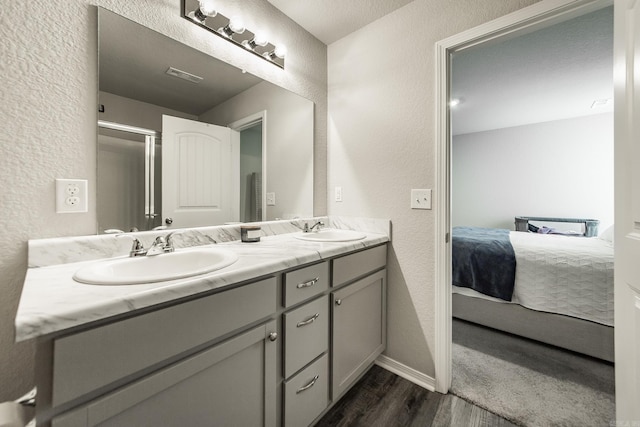 53 Dunnaway Dr, Ward, AR 72176 - ensuite bathroom featuring a textured wall, double vanity, and wood finished floors